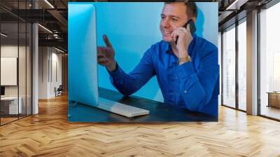 Creative millennial man using mobile phone and calling for business meeting, marketing manager making sell offer to customer, working in modern office loft Wall mural