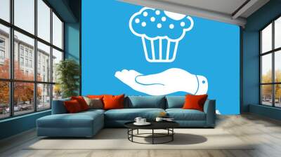 flat hand presenting white cake icon with cherry on a blue backg Wall mural