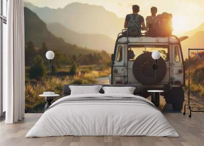 Two individuals are seated on the roof of a car traveling along a dusty rural road Wall mural