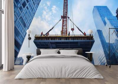 A crane lifting a steel beam into place on a skyscraper under construction, with workers guiding it Wall mural