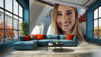 Beautiful female cabin crew air hostess smiling at the camera. Wall mural