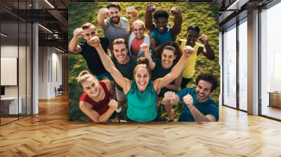 Let's do it, guys. Group of happy cheerful joyful energetic sporty diverse people standing on green grass in sunny park and motivating you to start day with outdoor fitness workout Wall mural