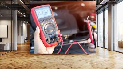 Asian technician measure voltage of battery in the car at service station, Maintenance and repair Wall mural