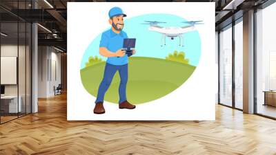 A young man flying a drone with remote control. Caucasian man operating a drone with remote control. The cheerful man controlling a drone. Wall mural