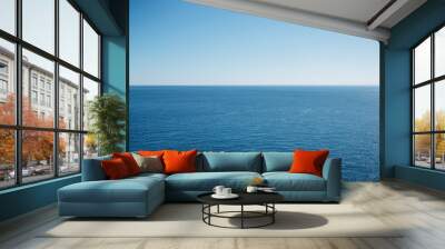 Clean blue sky above a blue surface of the sea. Wall mural