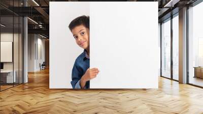 Portrait of a happy little boy holding a blank board against white background Wall mural