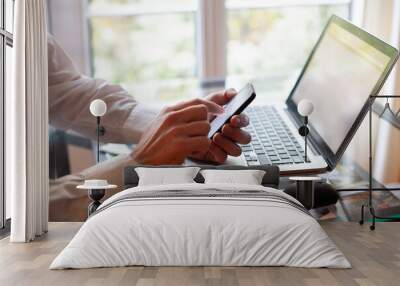 business man using smartphone and laptop in modern office with glass table Wall mural