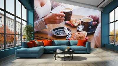 coffee and croissants in cafe, hands of couple closeup Wall mural