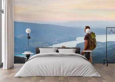 couple of hikers relaxing on top of mountain with beautiful panoramic view outdoors, two tourists backpackers during hike, adventure honeymoon Wall mural