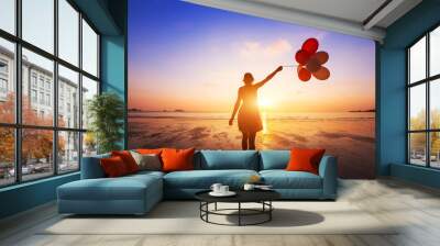 happiness concept, positive emotions, happy girl with multicolored balloons enjoying summer beach at sunset Wall mural