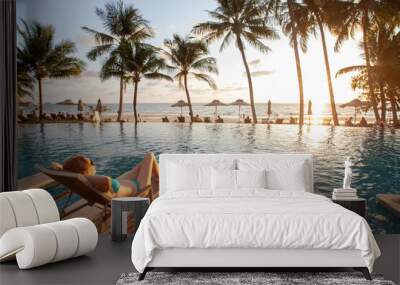 honeymoon couple relaxing in beach hotel near swimming pool at sunset, dream holidays Wall mural