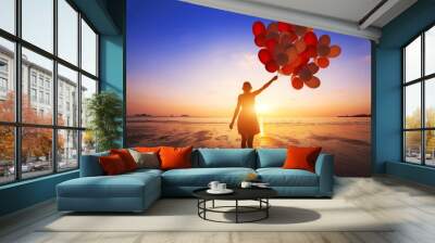 inspiration, joy and happiness concept, silhouette of woman with many flying balloons on the beach Wall mural