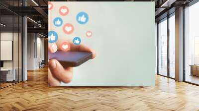 Social media and digital online communication concept, man using smartphone with likes icons on social media. Banner background. Wall mural