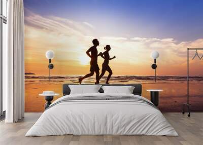 sport and healthy lifestyle, two people jogging at sunset on the beach Wall mural