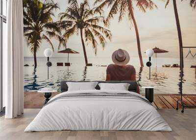 tourist in luxury beach hotel near luxurious swimming pool at sunset, tropical exotic holidays vacation, tourism and travel Wall mural