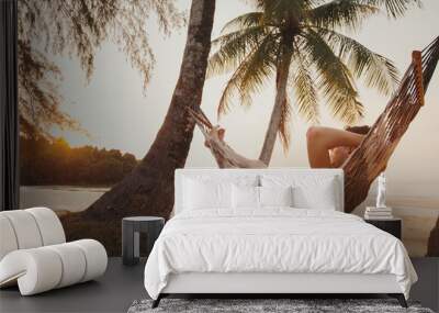 tourist relaxing in hammock on tropical beach with coconut palm trees, relaxation and leisure tourism Wall mural