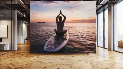 yoga on SUP, silhouette of man sitting in lotus position on stand up paddle board Wall mural