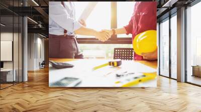 architect engineer shaking hands beside window - business teamwork, cooperation, success collaboration concept Wall mural