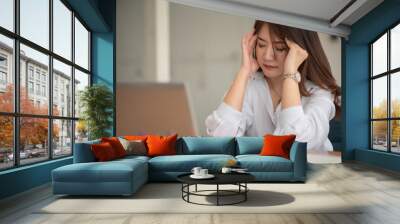 Asian businesswoman gets stressed while having a problem at work in the office. Wall mural