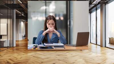 Asian women are stressed while working on laptops, Tired Asian businesswomen with headaches at the office, feeling sick at work, and copy space. Wall mural