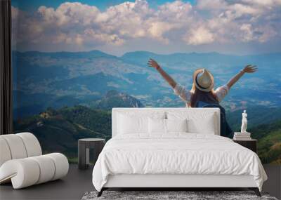 Freedom traveler girl standing with raised arms and enjoying a beautiful nature. Wall mural