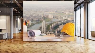 Yellow safety hard helmet with blueprint project on the city background Wall mural