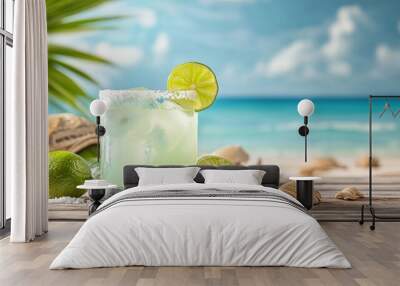 Margarita glass with salt rim and lime slice, beach scene in the background Wall mural