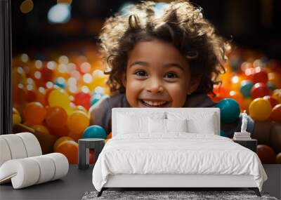 An adorable Indian kid playing happily in a colorful ball Wall mural