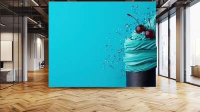   A blue cupcake topped with two cherries and sprinkled with frosting Wall mural