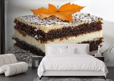   A cake on a white plate with a leaf next to a fork Wall mural