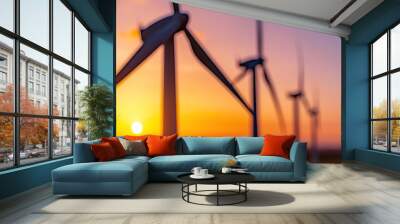   Row of wind turbines illuminated by the sun at dusk with a clear blue sky as the backdrop Wall mural