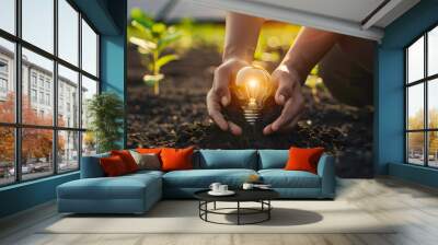 renewable energy light bulb with green energy, Earth Day or environment protection Hands protect forests that grow on the ground and help save the world, solar panels Wall mural