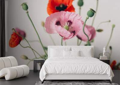 Beautiful poppies bouquet on wooden table in room. Gathering countryside wildflowers, rural still life. Red common poppy and purple opium poppy flowers in vase Wall mural