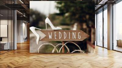 beautiful white shoes on wooden arrow with wedding text sign. rustic wedding concept. pointing for wedding ceremony location. creative ideas Wall mural