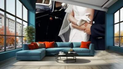 elegant gorgeous bride and stylish handsome groom holding hands close up, gentle touch. unusual luxury wedding in retro style. amazing romantic moment Wall mural