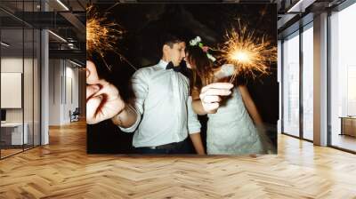 happy beautiful bride and elegant stylish groom holding firework Wall mural