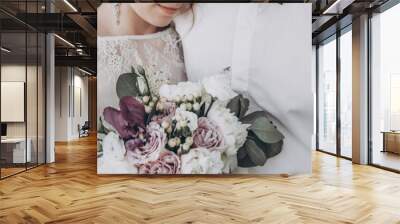 stylish wedding couple with bouquet. modern bride and groom holding fashionable bouquet and embracing in sunny garden. fine art wedding photo, romantic moment Wall mural