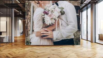 stylish wedding couple with bouquet. modern bride and groom holding fashionable bouquet at old  castle. fine art wedding photo, romantic moment, long edge Wall mural