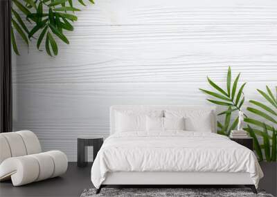 summer flat lay. fresh palm leaves border on white wooden background with space for text. top view.  Wall mural