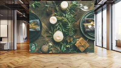 Christmas or New Years celebration party table setting. Flat-lay of plates, golden cutlery, festive branch decoration, candles and gliterring toys over wooden table background, top view Wall mural