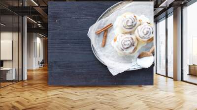 Cinnamon rolls with cream-cheese icing and cinnamon sticks on a Wall mural