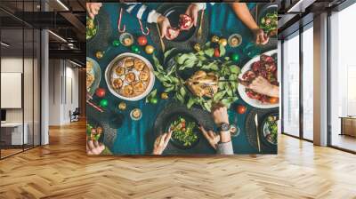 Company of friends of different ages gathering for Christmas or New Year party dinner at festive table. Flat-lay of human hands eating meals and celebrating holiday, top view Wall mural