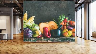 Fall vegetarian food ingredients. Assortment of various Autumn vegetables for healthy cooking over rustic cupboard, dark wall background, copy space, selective focus. Local market organic produce Wall mural