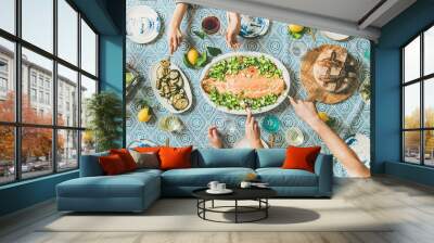 Family or friends summer party or seafood dinner. Flat-lay of group of mutinational people with different skin color at big table eating delicious food together. Summer gathering or celebration Wall mural