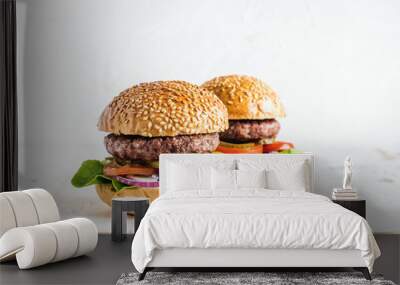 Fresh homemade burgers on wooden serving board with onion rings. Wall mural