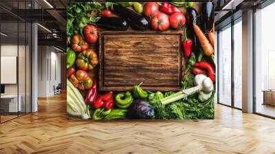 Fresh raw vegetable ingredients for healthy cooking or salad making with rustic wood board in center, top view, copy space Wall mural