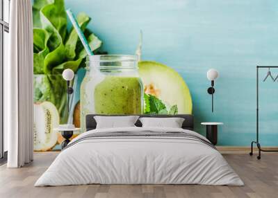 Freshly blended green fruit smoothie in glass jar with straw Wall mural