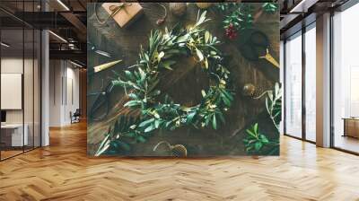 Getting ready for Christmas. Flat-lay of green olive branch festive wreath, Christmas tree decoration toys, gift box and scissors over rustic wood table background, top view, horizontal composition Wall mural