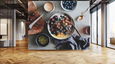 Healthy vegan breakfast. Flat-lay of quinoa oat granola coconut yogurt bowl with fresh fruit, honey, seed, nut, berries and cup of coffee over grey background, top view. Clean eating food concept Wall mural