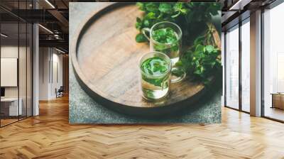 Hot herbal mint tea drink in glass mugs with fresh garden mint leaves over wooden tray over concrete background, selective focus, copy space, horizontal composition Wall mural